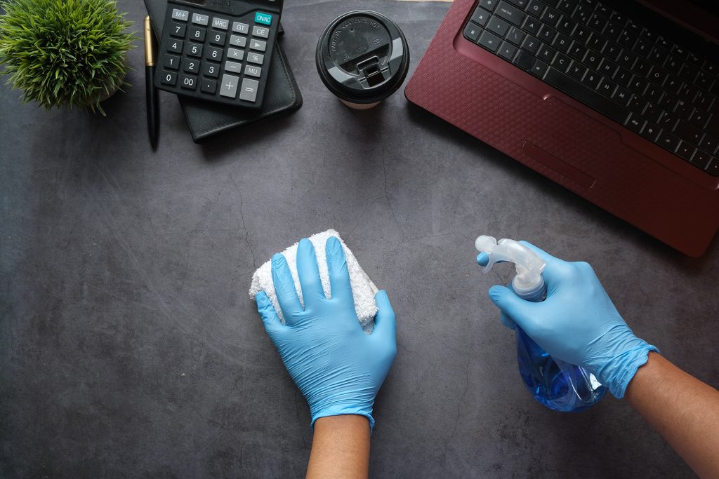 Cleaning a desk with spray cleaner